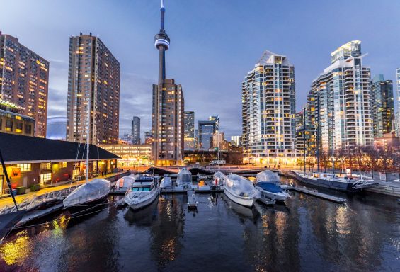 Puerto deportivo de Toronto al atardecer, con rascacielos y la CN Tower de fondo.