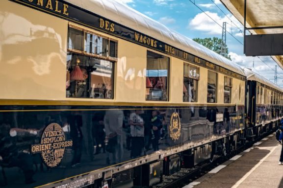 Vagón de tren clásico en una estación, con detalles en azul y dorado.